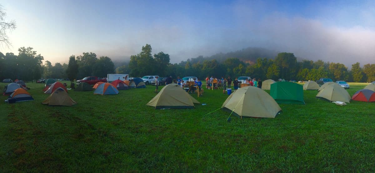 Tents pitched across a misty outdoor camping field at dawn