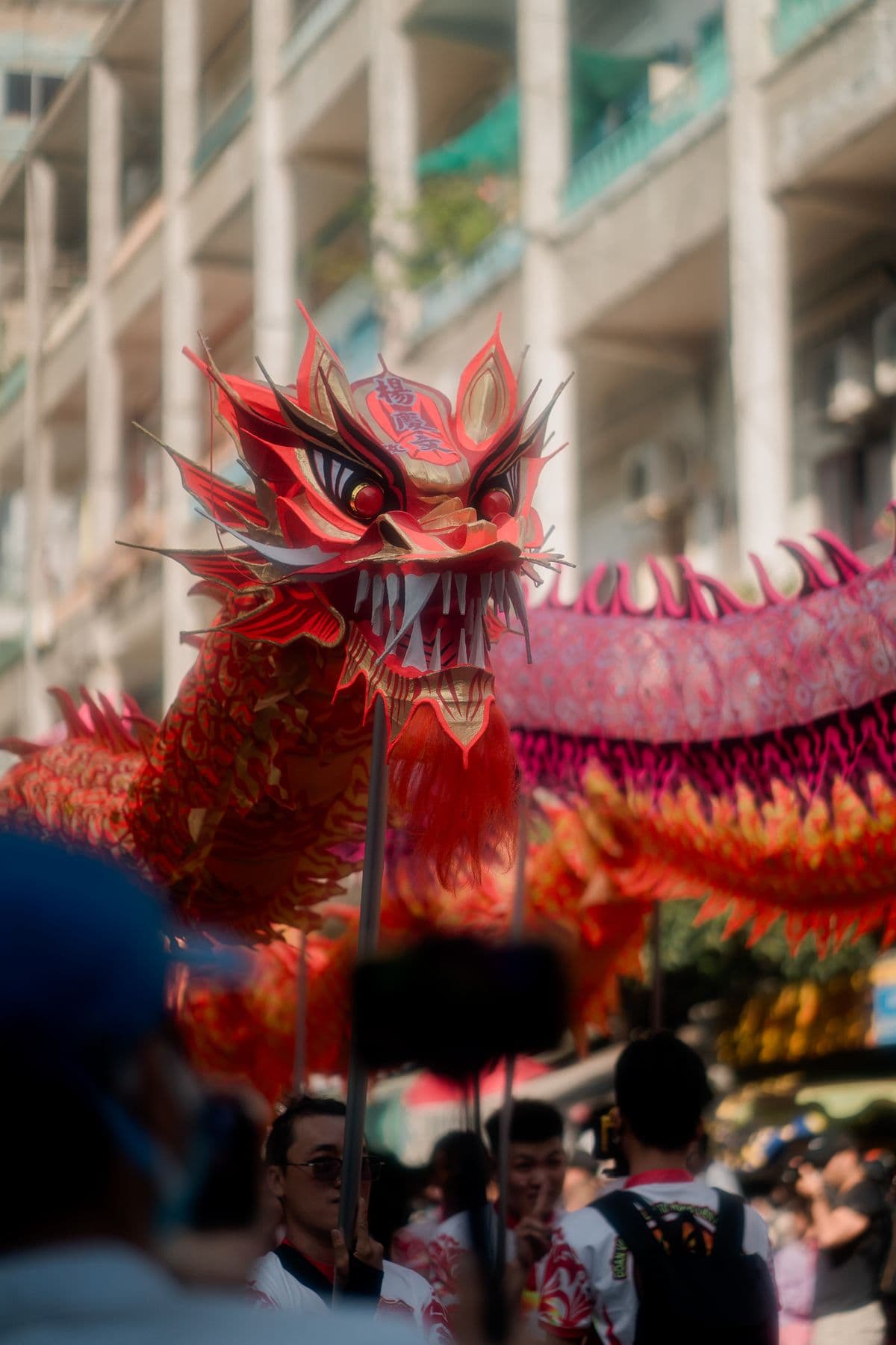 A traditional dragon dance performance moving through a city street