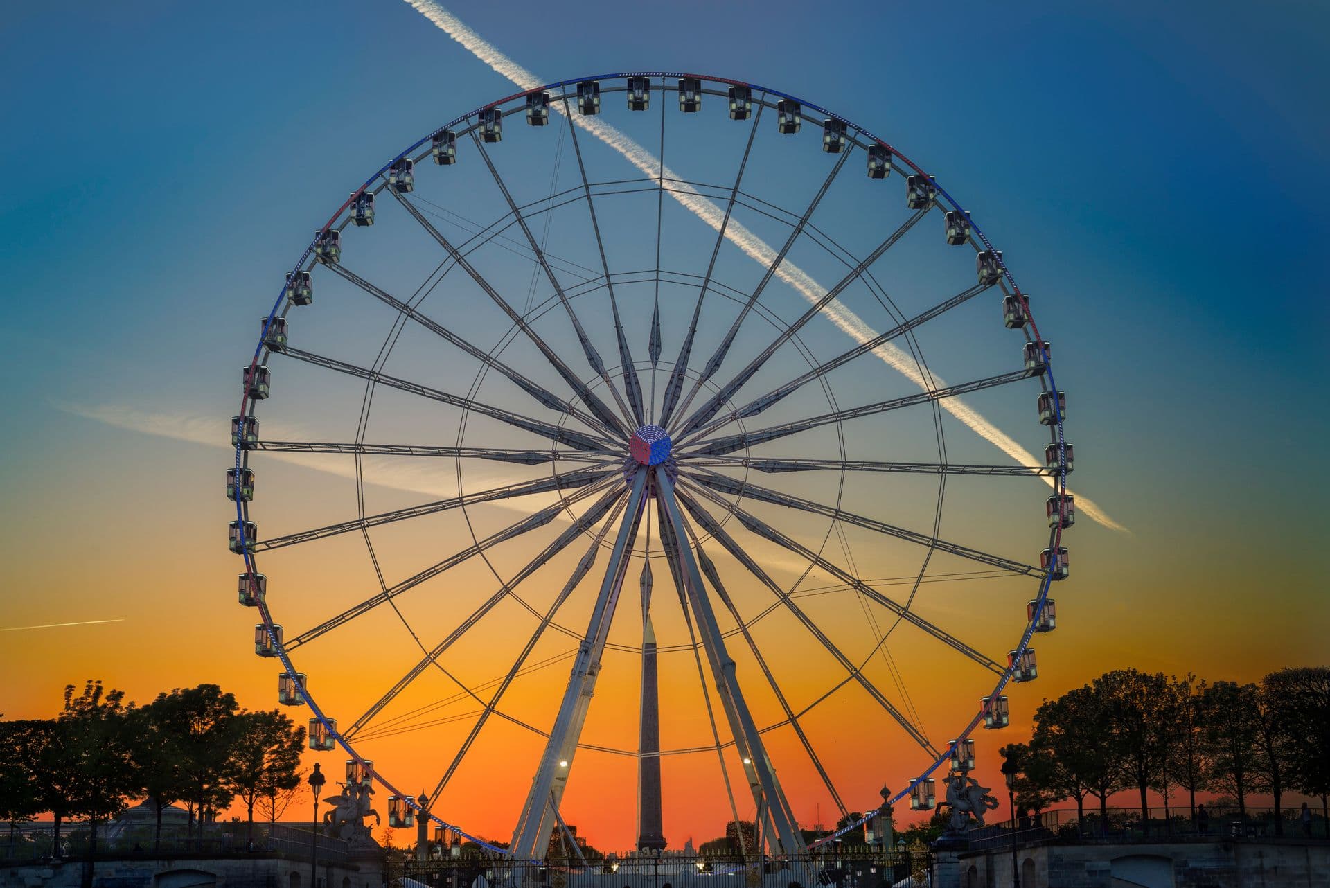 A ferris wheel silhouetted against a sunset sky