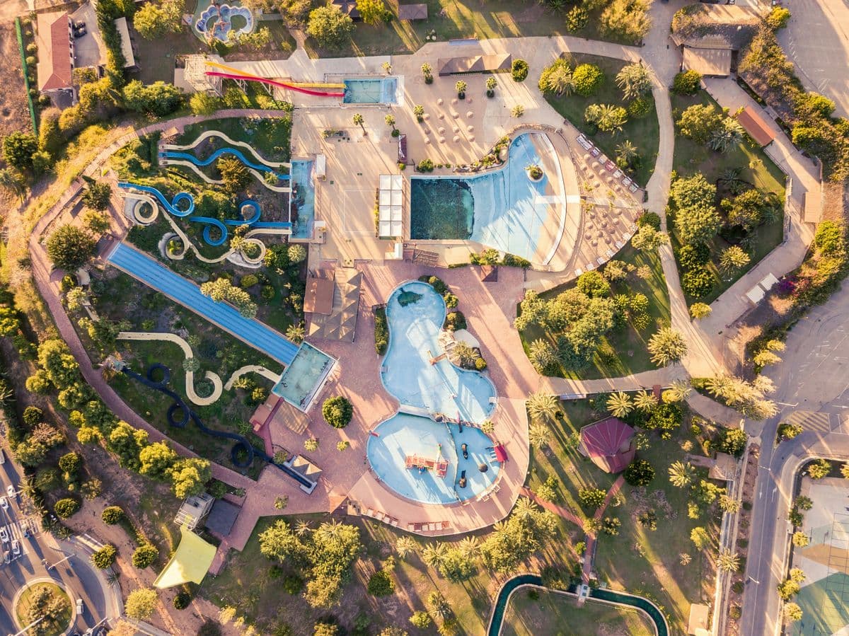Aerial view of a water park's pools and slides at golden hour